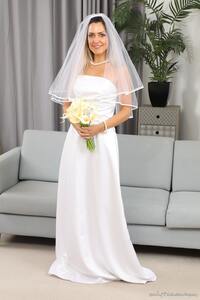 Green-eyed bride Miss V smiles enchantingly as she takes off her wedding dress and reveal legs in white stockings