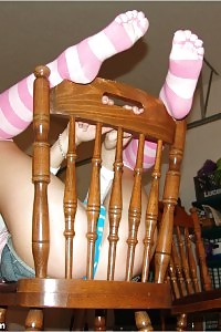 Sea Poses In The Chair As She Pulls Up Her Denim Skirt